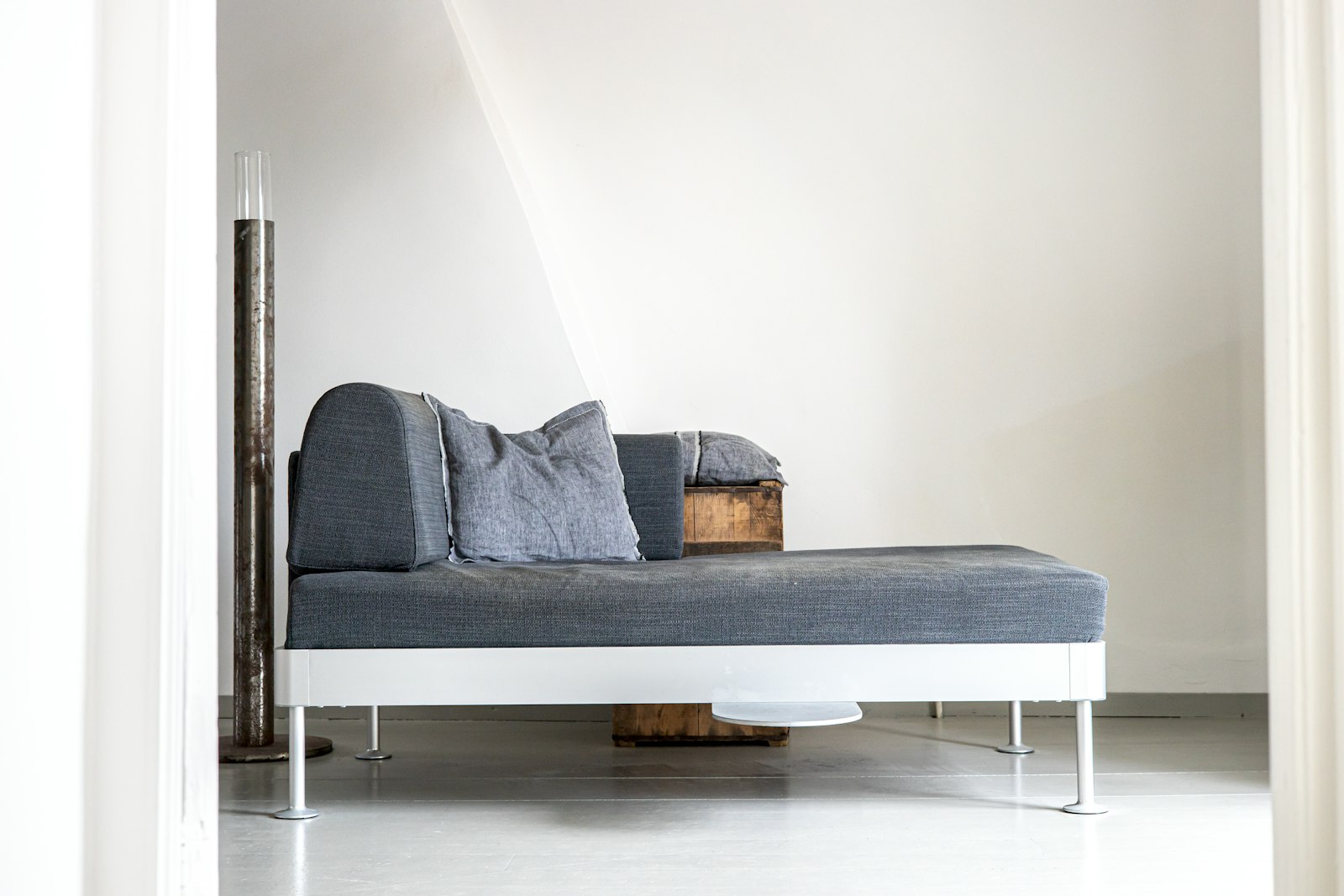 Beige bank met chaise longue aan de linkerkant in een lichte woonkamer bij het raam